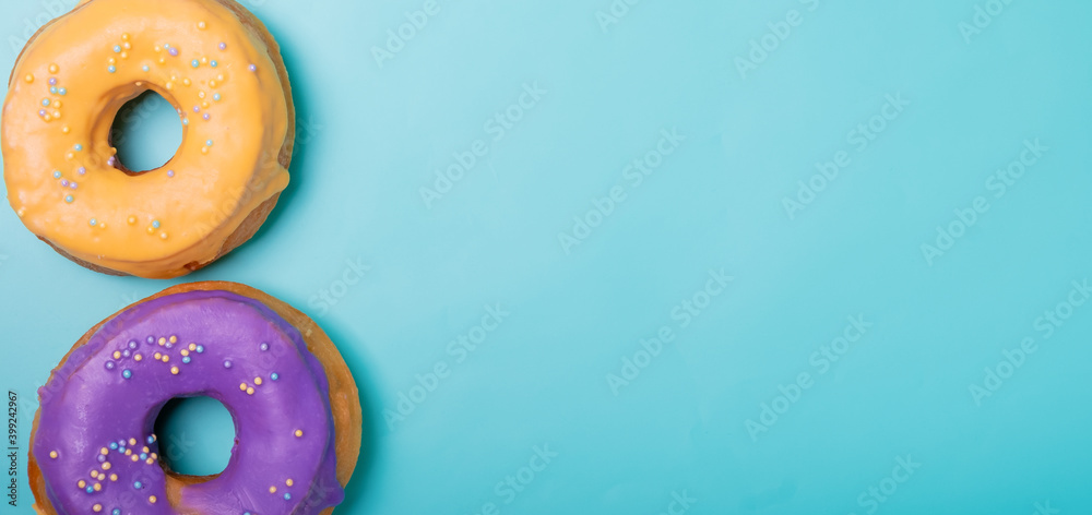 Two donuts on a light blue background with free space on the right. Two donuts on a light blue background with free space on the right.