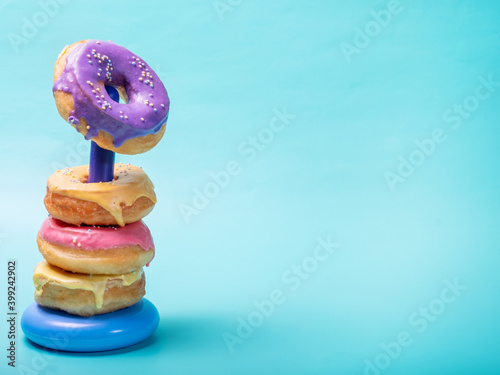 Donuts of different colors on a children's toy, concept. Blue bright background with free space.