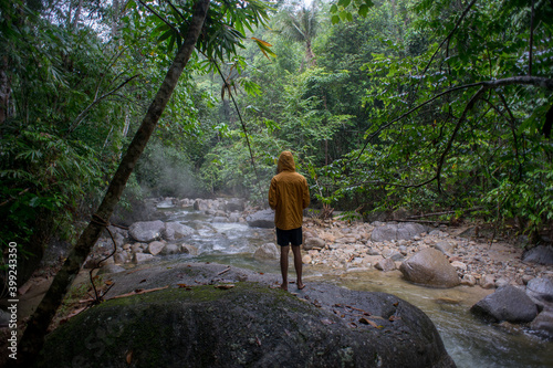 Male traveler explore the beautiful of rainforest stream in the morning.Male traveler camping in the rainforest.Grain effects and tone color applied.