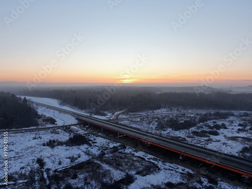 Aerial view of the Central Ring Road (CKAD) at sunrise. Beautiful panoramic landscape of a straight road overlooking the horizon. Travel by car in winter
