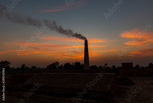 brickkiln  in India and Pakistan  , bricks making in traditional way by hands , smoke in chimney of bricks factory  photo