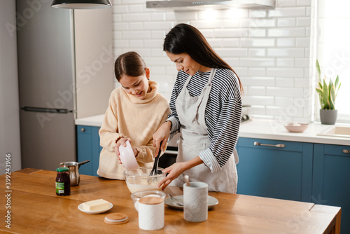 Happy mother and daughter cooking breakfast together
