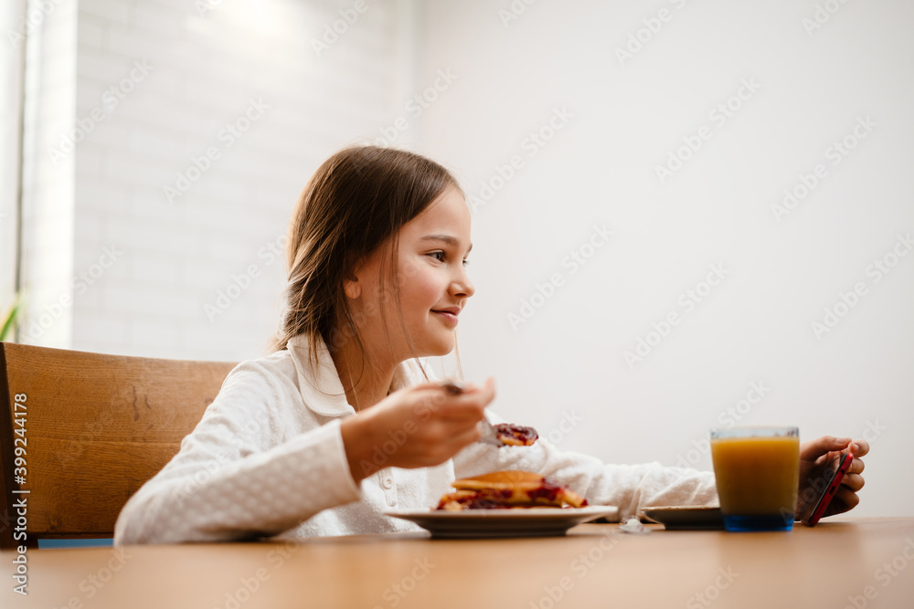 Little girl having breakfast while watching movie Little girl having breakfast while watching movie