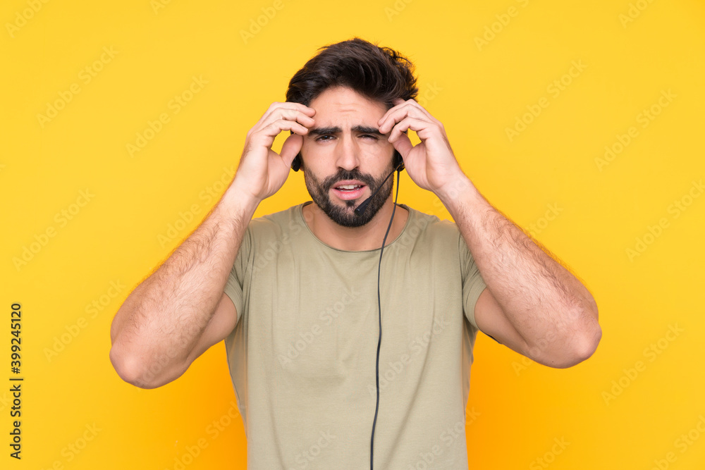 Telemarketer man working with a headset over isolated yellow background unhappy and frustrated with something. Negative facial expression Telemarketer man working with a headset over isolated yellow background unhappy and frustrated with something. Negative facial expression