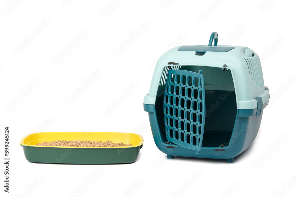 large plastic carrier cage for cats and dogs and cat litter box filled with pressed sawdust