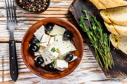 Antipasti platter with fresh feta cheese, bread and olives. White wooden background. Top view