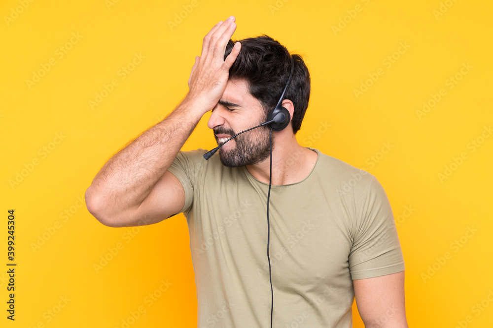 Telemarketer man working with a headset over isolated yellow background having doubts with confuse face expression Telemarketer man working with a headset over isolated yellow background having doubts with confuse face expression