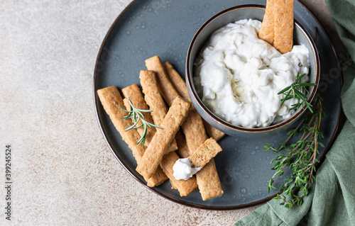 Blue cheese dressing or dip sauce with rosemary and gingerbread cookies sticks on concrete background. photo