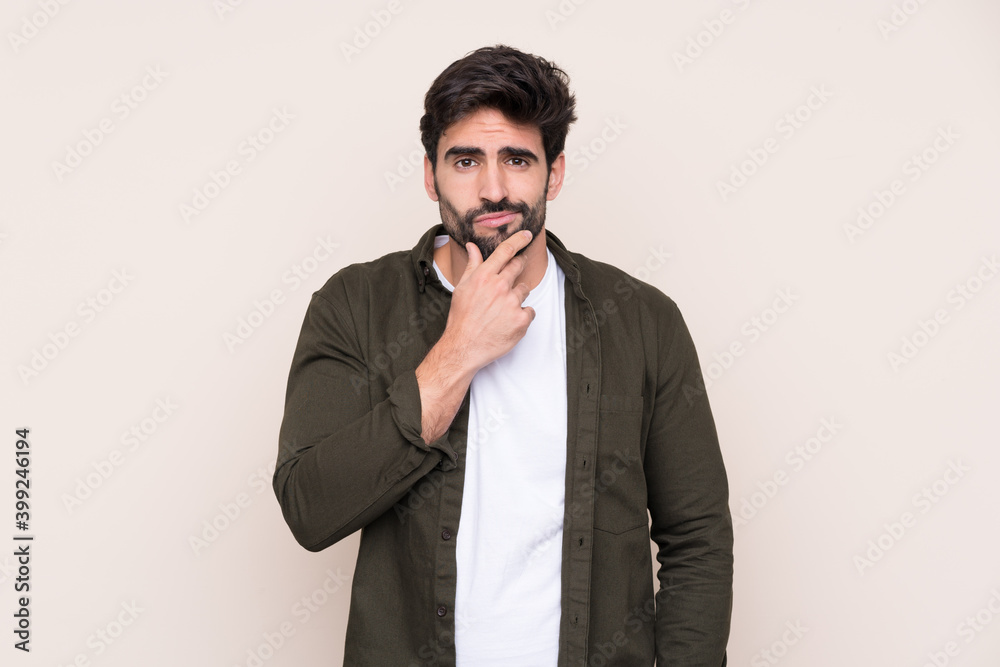 Young handsome man with beard over isolated background thinking Young handsome man with beard over isolated background thinking