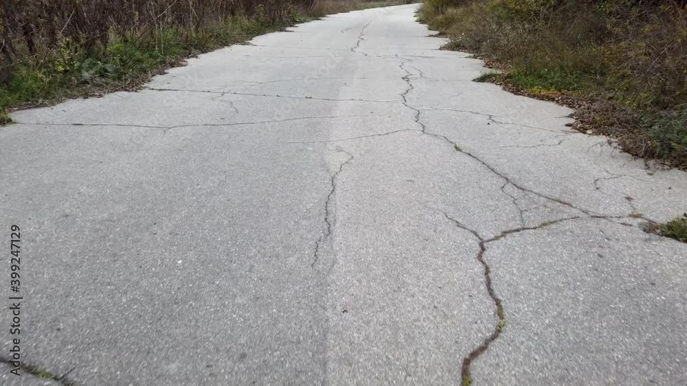 Walking through empty old asphalt road in countryside.