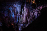 Stalagmites lit by colored lights, cave, Lozère, Occitanie, France