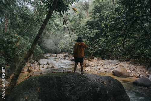 Male traveler explore the beautiful of rainforest stream in the morning.Male traveler camping in the rainforest.Grain effects and tone color applied.