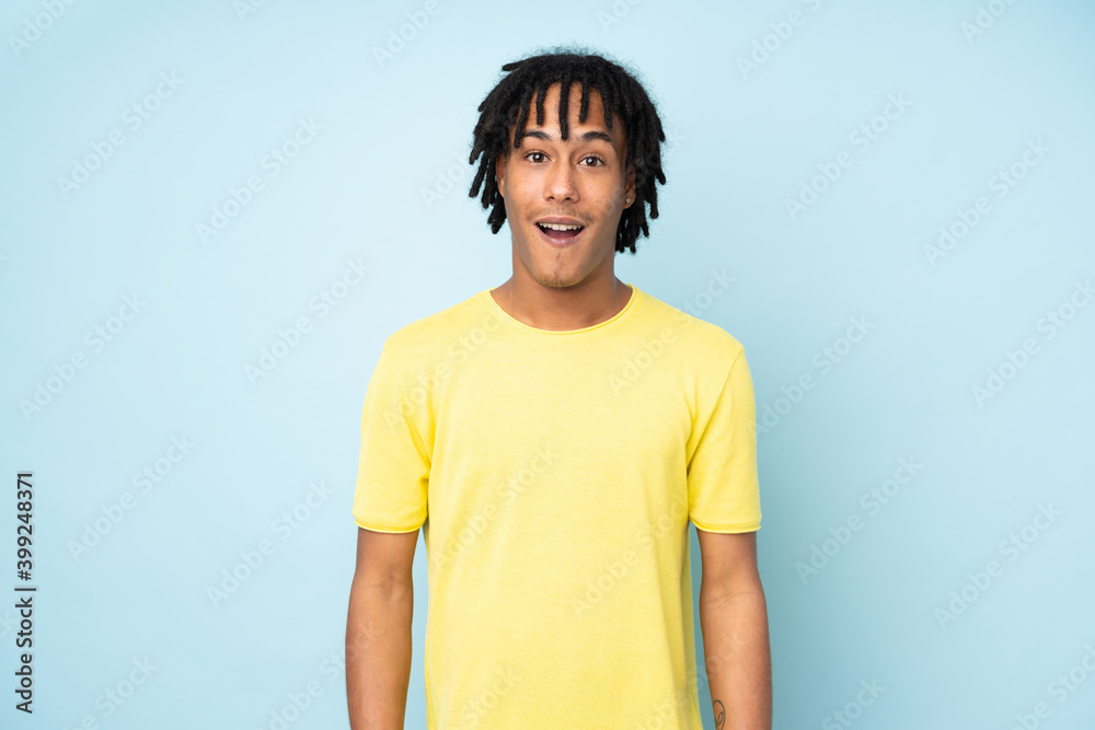 Young african american man isolated on blue background with surprise facial expression Young african american man isolated on blue background with surprise facial expression