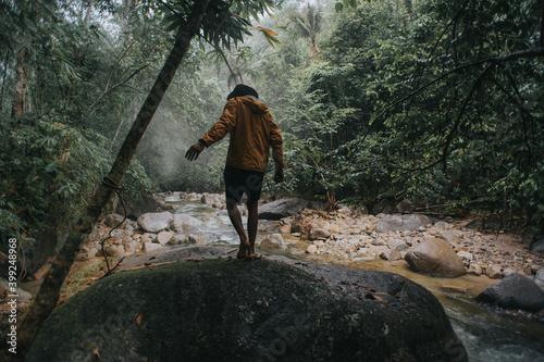 Male traveler explore the beautiful of rainforest stream in the morning.Male traveler camping in the rainforest.Grain effects and tone color applied.