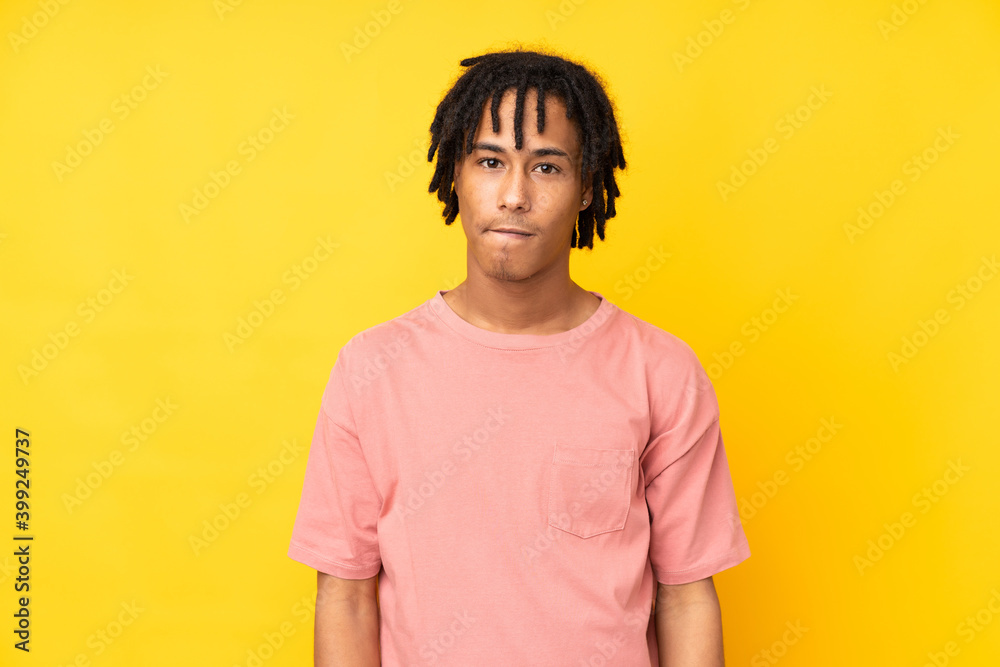 Young african american man isolated on yellow background with confuse face expression