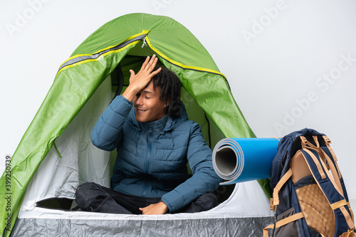 Young african american man inside a camping green tent has realized something and intending the solution