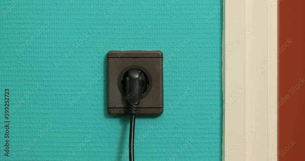 Electric outlet plugging and unplugging a black power cord, European Type F Electric outlet plugging and unplugging a black power cord, European Type F