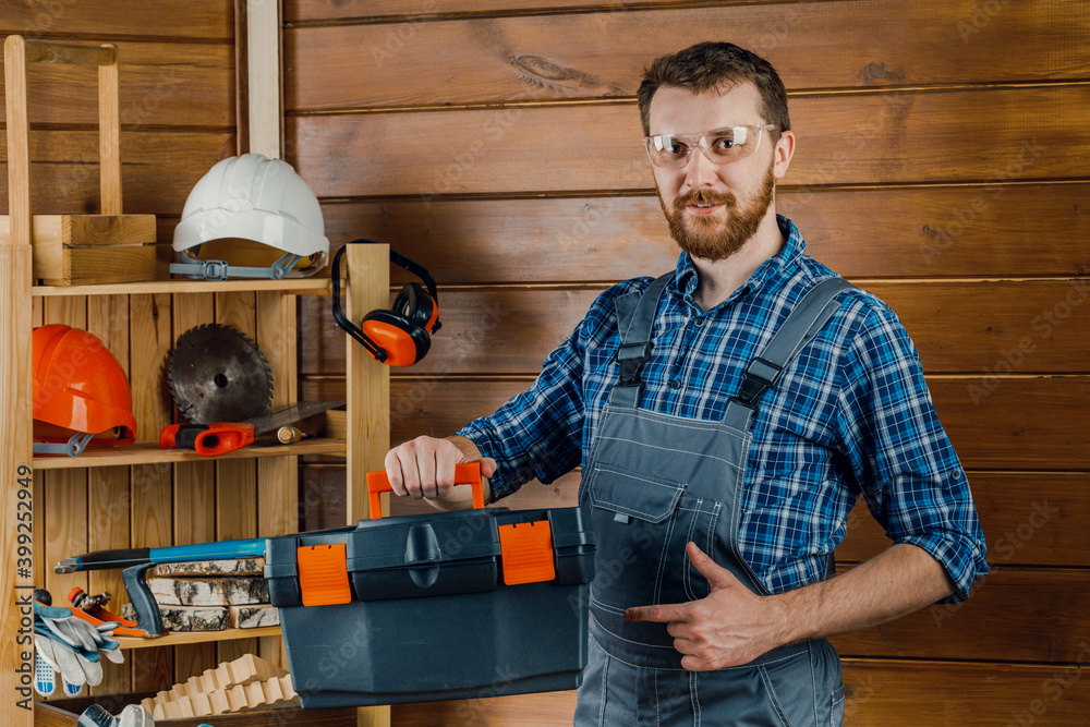 Construction and repair - a male worker or Builder with working tools in a box Construction and repair - a male worker or Builder with working tools in a box