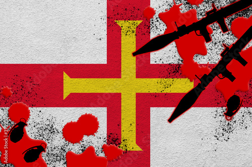 Guernsey flag and rocket launchers with grenades in blood. Concept for terror attack and military operations photo