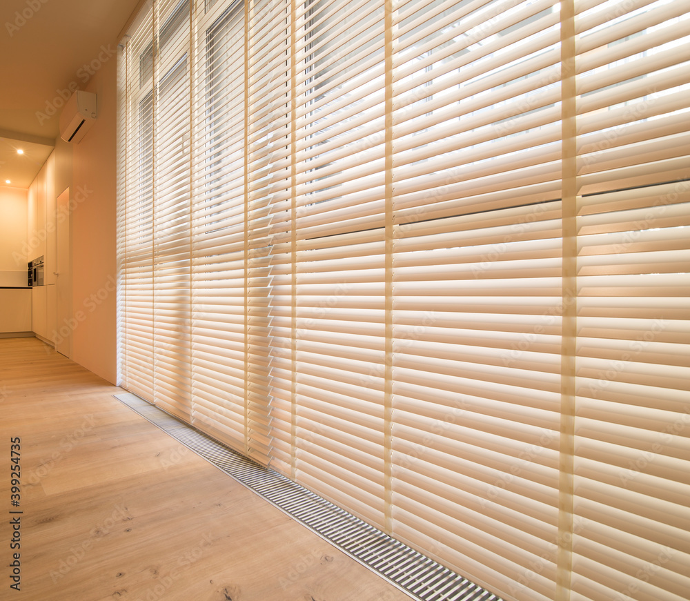 Motorized wood blinds in the interior. Automatic venetian blinds beige  color on large windows. Coulisse wooden slats 50mm wide. Wood floor, beige  walls. Stock Photo | Adobe Stock