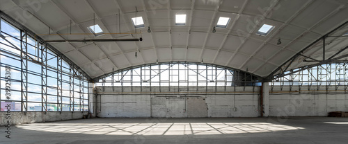 Huge empty industrial warehouse. White interior. Unique architecture. Hemispherical reinforced concrete load bearing roof. Modern building.