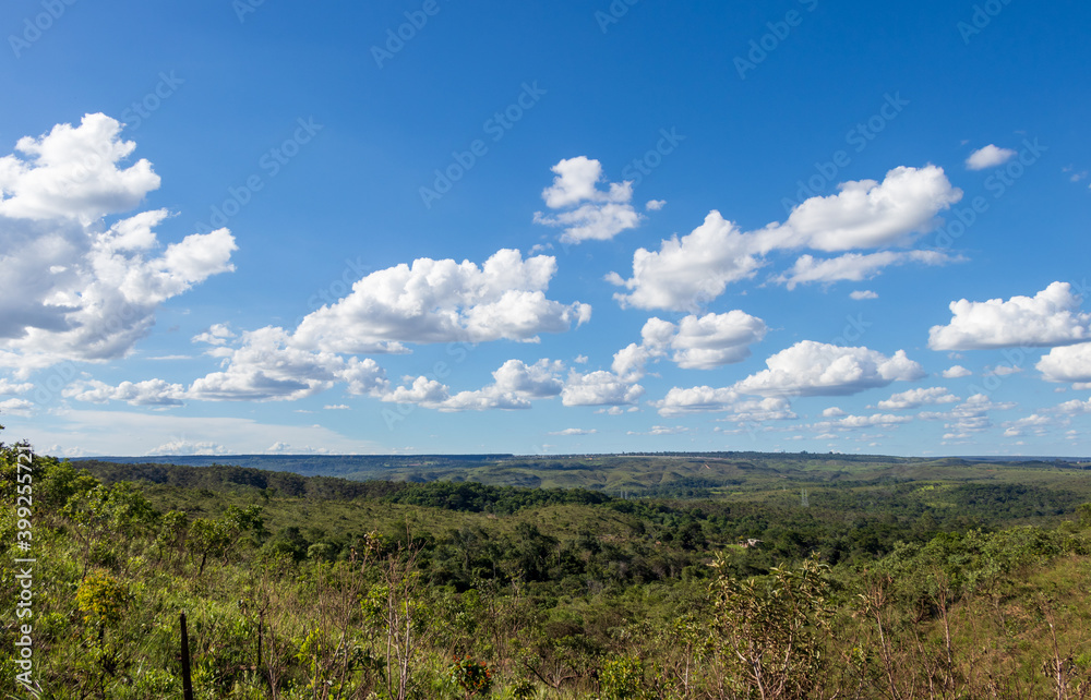 Montanhas e vales com céu azul e algumas nuvens.