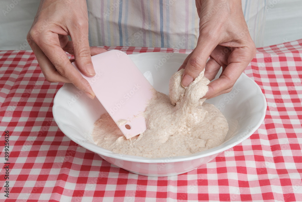 Kneading a dough of bread in a bowl. Female hands working. Making pizza. Cooking at home. Homemade food. Italian cloth. Kneading a dough of bread in a bowl. Female hands working. Making pizza. Cooking at home. Homemade food. Italian cloth.