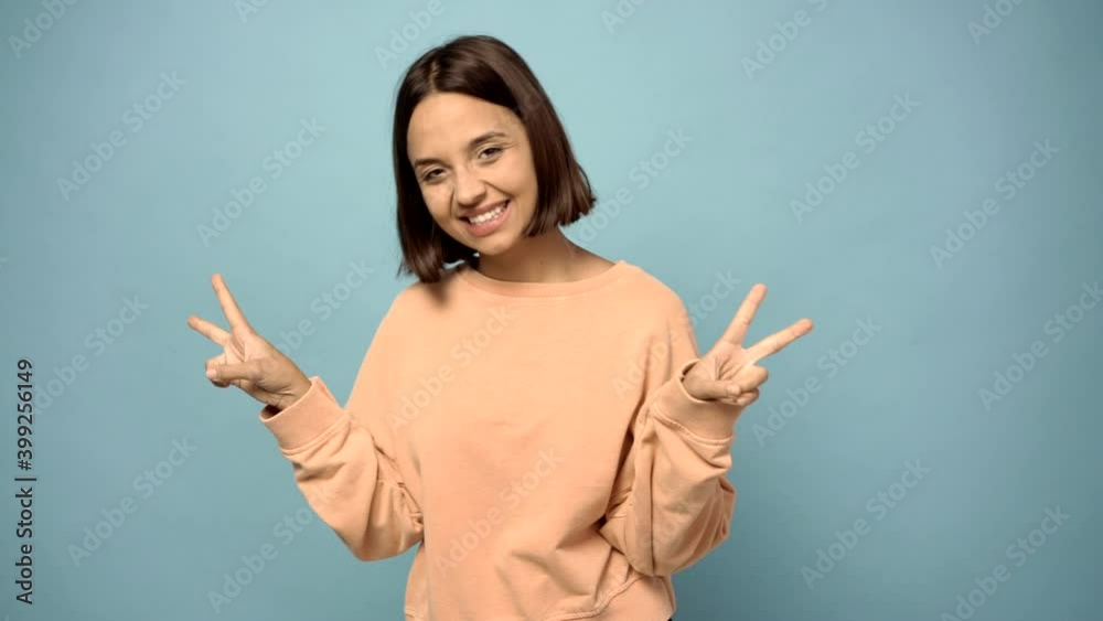 woman smiling and showing victory sign with a cheerful face woman smiling and showing victory sign with a cheerful face