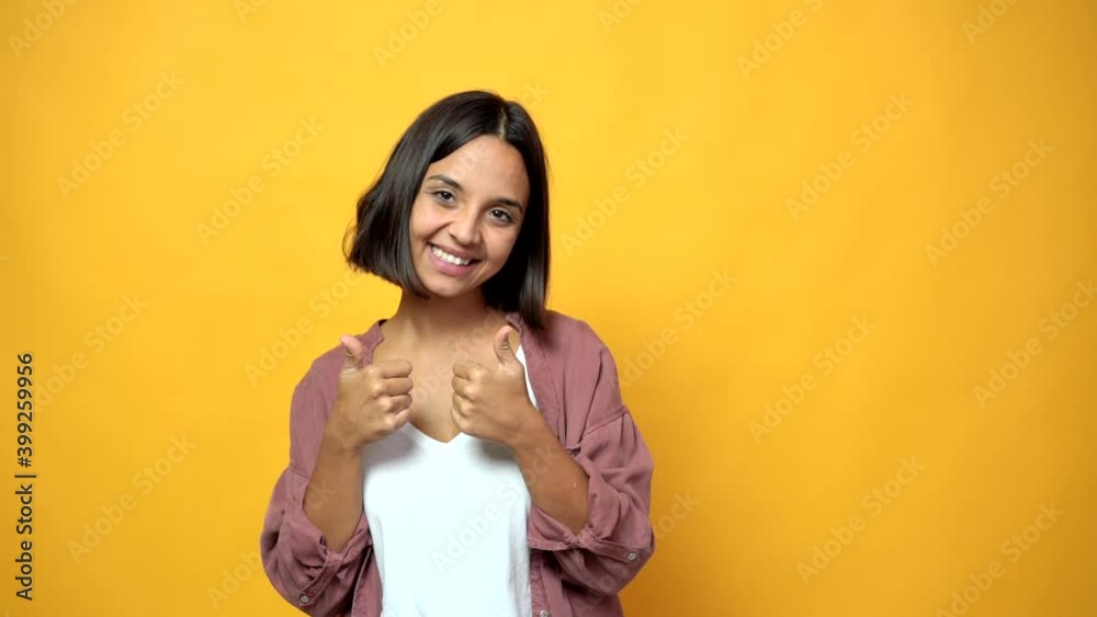 woman giving thumbs up and smiling because something good has happened woman giving thumbs up and smiling because something good has happened