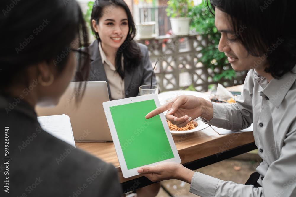 Portrait cheerful of young asian business team meeting in a cafe showing copy space in tablet. Portrait cheerful of young asian business team meeting in a cafe showing copy space in tablet.