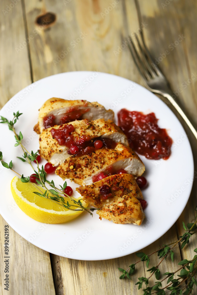 Juicy turkey fillet in slices with cranberry sauce on a plate. Festive food. Juicy turkey fillet in slices with cranberry sauce on a plate. Festive food.
