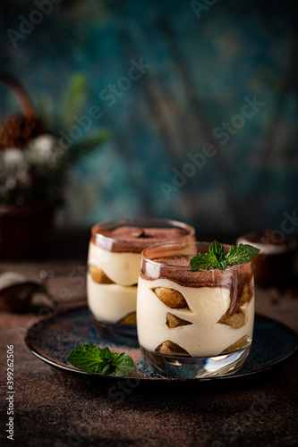 Traditional Italian dessert tiramisu in a glass on on dark background