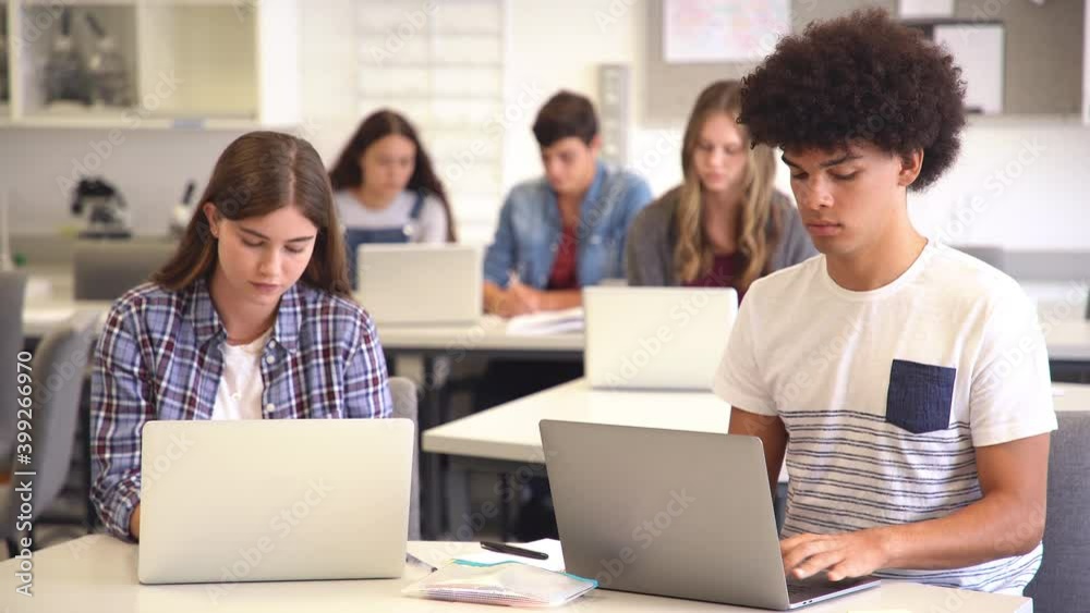 College student using laptop in class during computer lesson. Black high school student studying on laptop in university library with his classmate. College student using laptop in class during computer lesson. Black high school student studying on laptop in university library with his classmate.