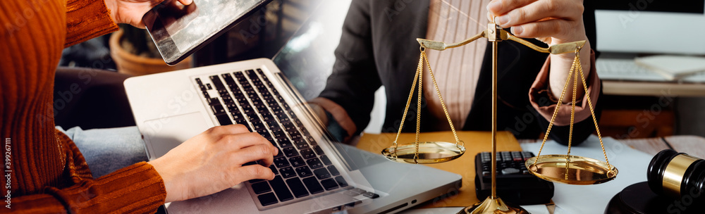 Fototapeta premium Business and lawyers discussing contract papers with brass scale on desk in office. Law, legal services, advice, justice and law concept picture with film grain effect