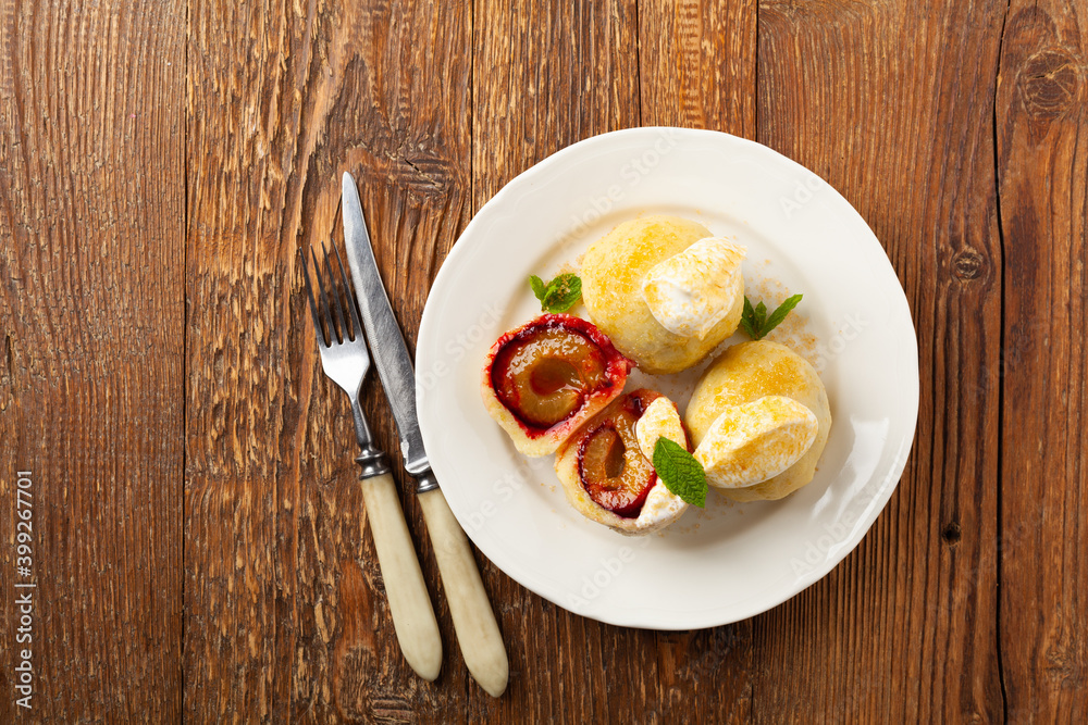 Dumplings with plums, topped with plum sauce or served with cream and sugar. Dumplings with plums, topped with plum sauce or served with cream and sugar.