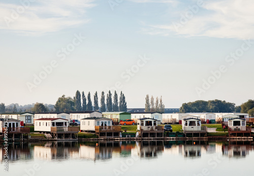 Holiday park of static caravans on edge of river or lake.