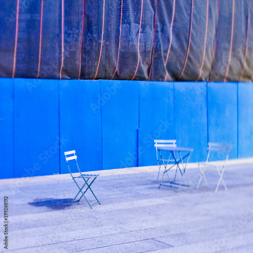 Folding chairs in front of construction site hoarding.
