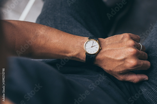 fashionable wearing stylish looking at luxury watch on hand check the time at workplace.concept for managing time organization working,punctuality,appointment