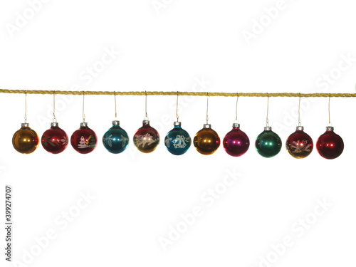 Festive glass balls on a cord of gold color isolated on a white background.