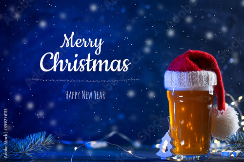 Merry Christmas and happy new year toast greetings  a glass of beer ale in a red hat  creative concept greeting card