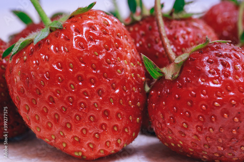 Fresh ripe strawberry on textured white table. Close-up. Macro.