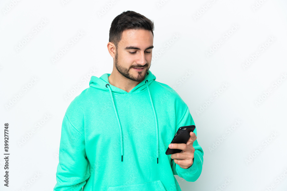 Young caucasian handsome man isolated on white background sending a message or email with the mobile Young caucasian handsome man isolated on white background sending a message or email with the mobile