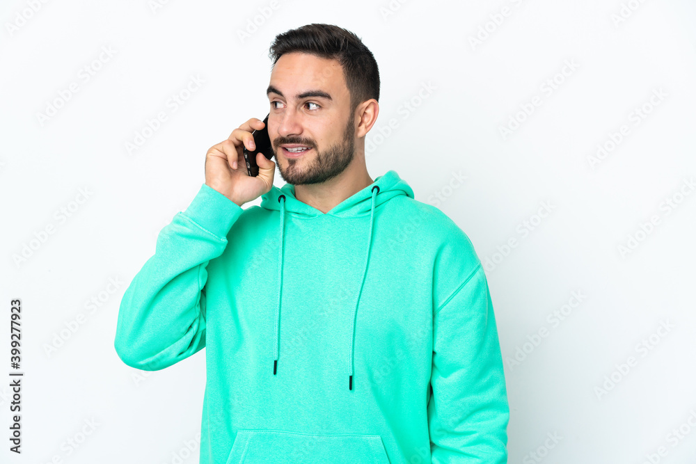 Young caucasian handsome man isolated on white background keeping a conversation with the mobile phone with someone Young caucasian handsome man isolated on white background keeping a conversation with the mobile phone with someone