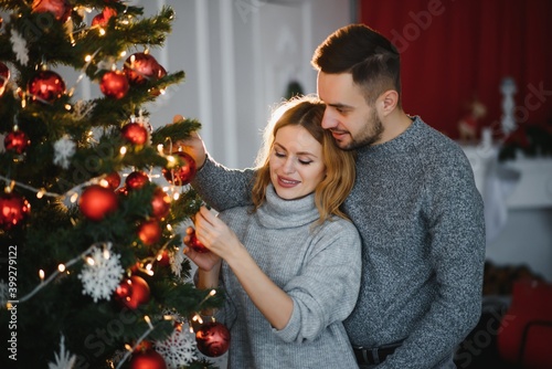 Romantic couple in love feeling happiness about their romance spending christmas eve together, woman and man enjoying perfect relationships and spending winter vacations in cozy home interior © Serhii