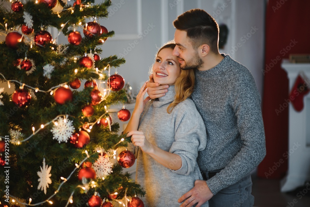 Romantic couple in love feeling happiness about their romance spending christmas eve together, woman and man enjoying perfect relationships and spending winter vacations in cozy home interior