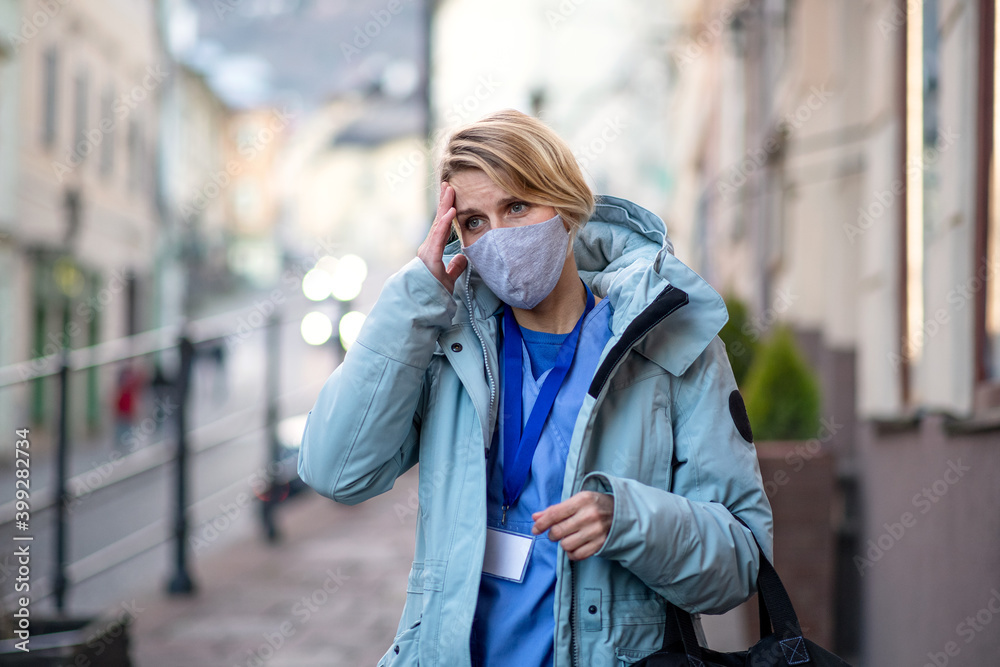 Fototapeta premium Woman caregiver, nurse or healthcare worker outdoors on the way to work, coronavirus concept.