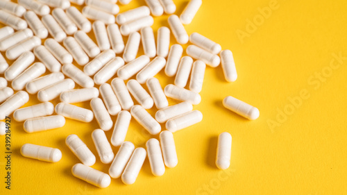 A pile of magnesium supplement capsules isolated on a yellow background. Food supplement. Vitamin D3