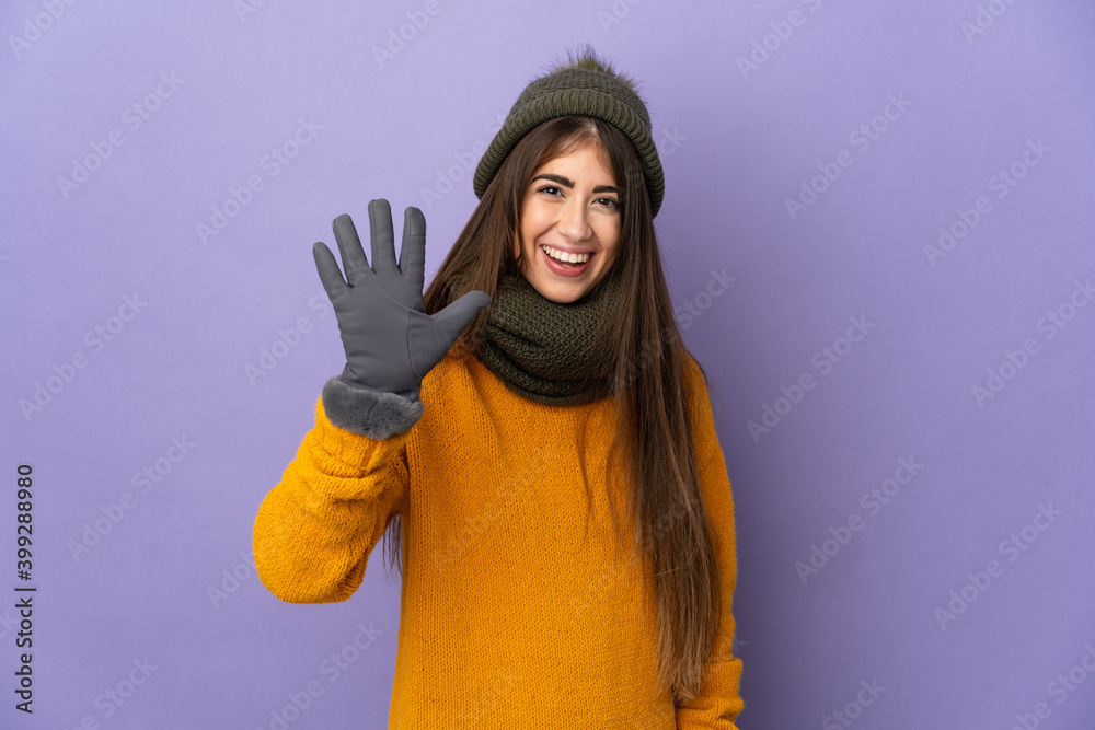 Young caucasian girl with winter hat isolated on purple background counting five with fingers Young caucasian girl with winter hat isolated on purple background counting five with fingers