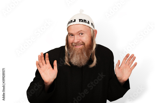 Obraz na płótnie Smiling bearded Orthodox jewish man isolated on white background. Cheerful charismatic Jew with sidelocks in white yarmulke showing palms and hinting that he has nothing to do with it. w salonie