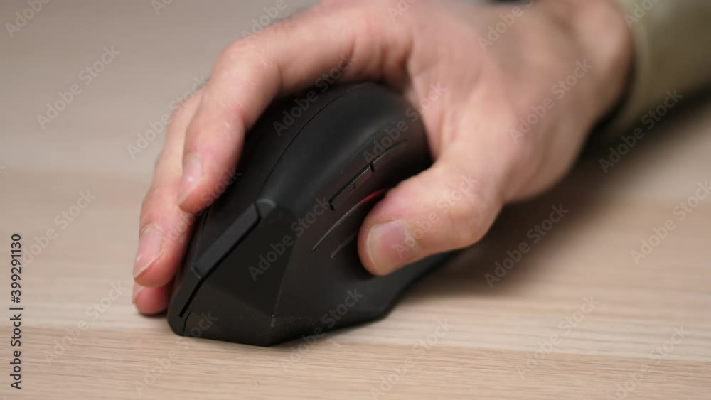 Closeup on the hand of a man using a computer mouse to navigate. Closeup on the hand of a man using a computer mouse to navigate.